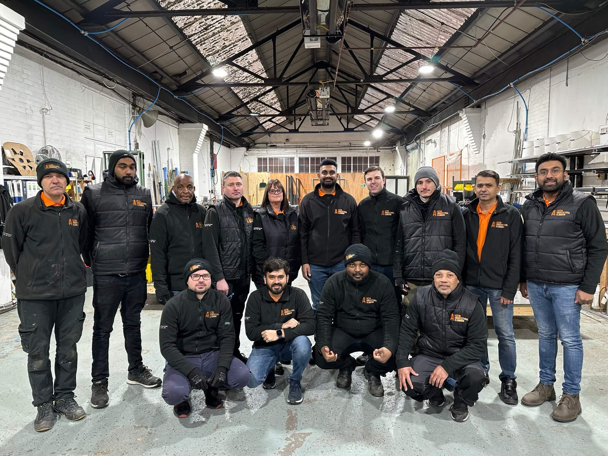 The team of Aston Architectural standing inside there factory.